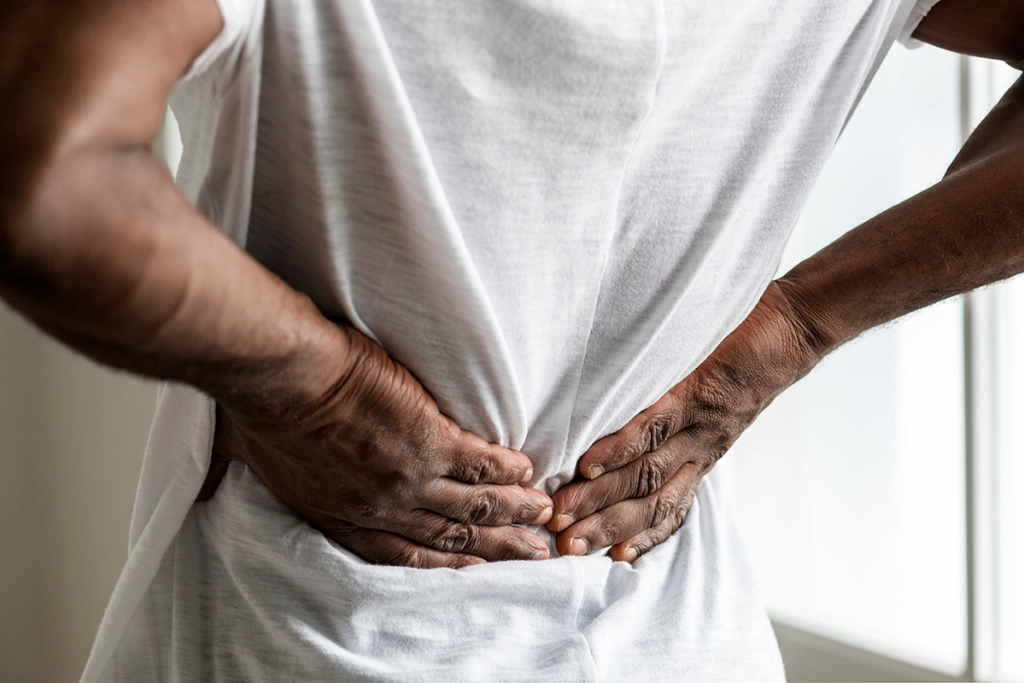 Male with hands on lower back as if in pain
