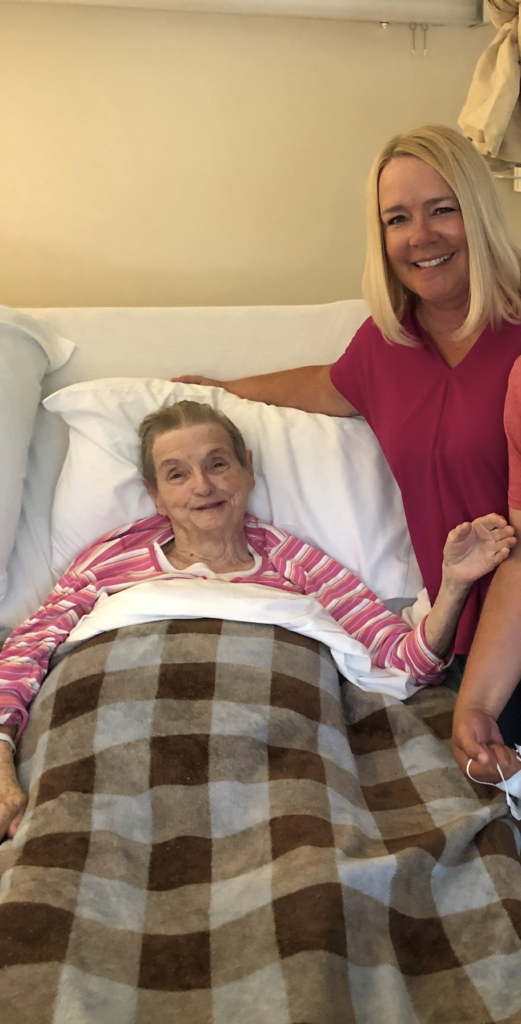 Angela visits her Granny during her time in hospice, smiling as they match wearing pink shirts. 