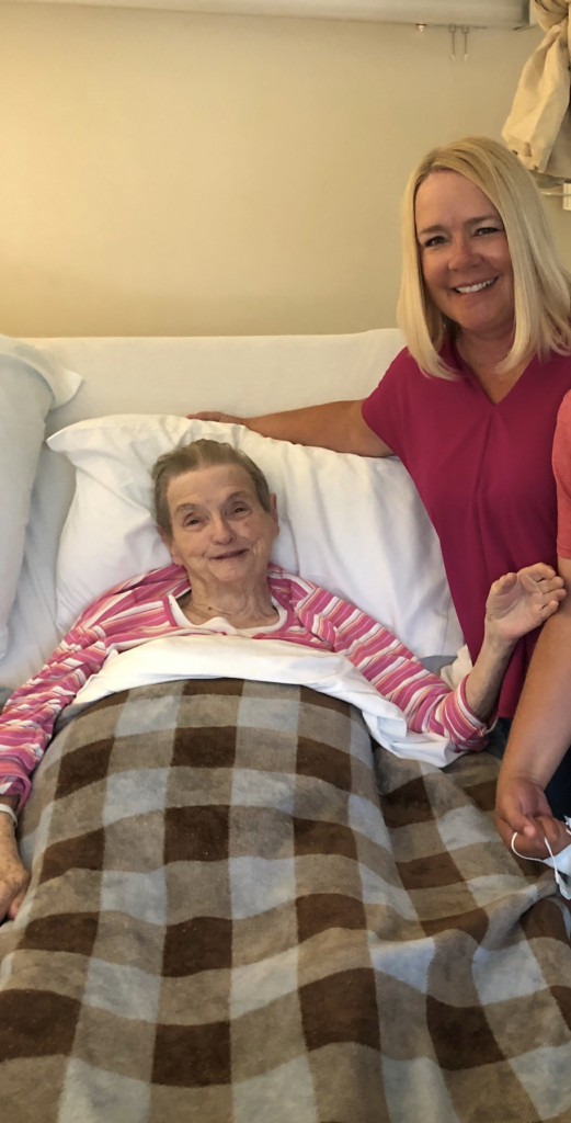 Angela visits her Granny during her time in hospice, smiling as they match wearing pink shirts.