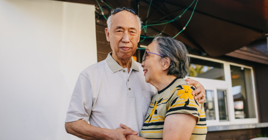 Caring for a loved one with dementia can feel difficult, but with patience, acceptance and the right resources, caregivers can learn how, like the one pictured in this image, holding his loved ones hand as she smiles up at him.