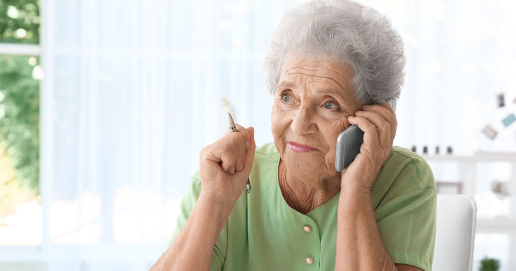 Patients can contact the care management division by phone at any point to get advice, support or additional resources. This photo depicts an older woman wearing green who is on the phone.