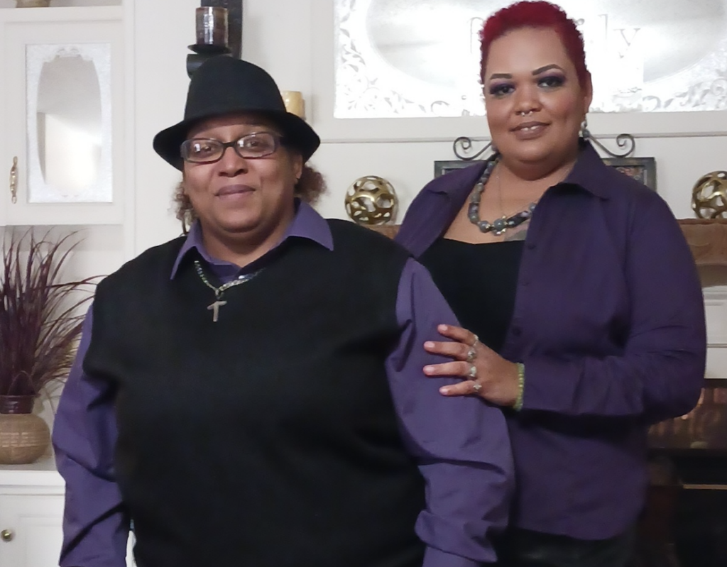 Enhabit Cares grant recipient Terri (right) and her family member (lef) smile for the camera, matching in purple and black clothes. 