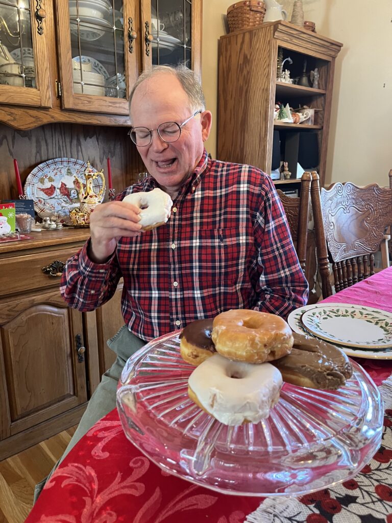 Enhabit patient John's stroke recovery goal was to eat a donut again with his right hand. He is pictured holding a donut up to his mouth