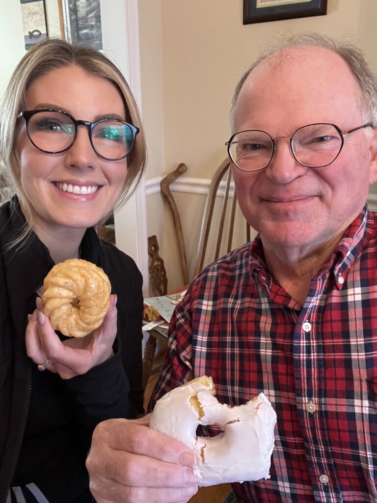 Enhabit patient John's stroke recovery goal was to eat a donut again with his right hand. He is pictured smiling with his occupational therapist Courtney after taking a bite out of his donut