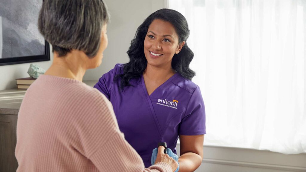 A home health cllinician at Enhabit is working with a patient to demonstrate a career in home health