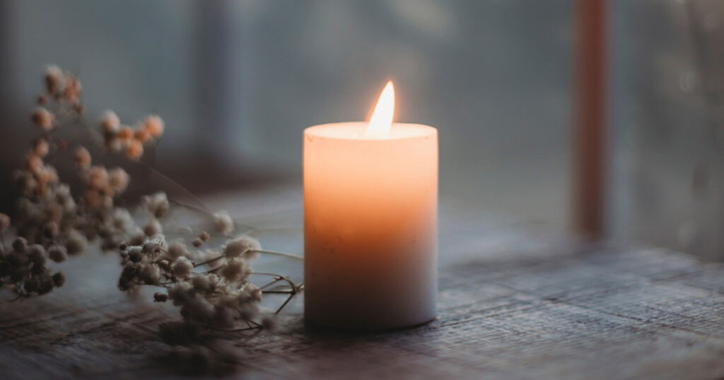 A single candle burns to represent grief and bereavement after a loved one passes away